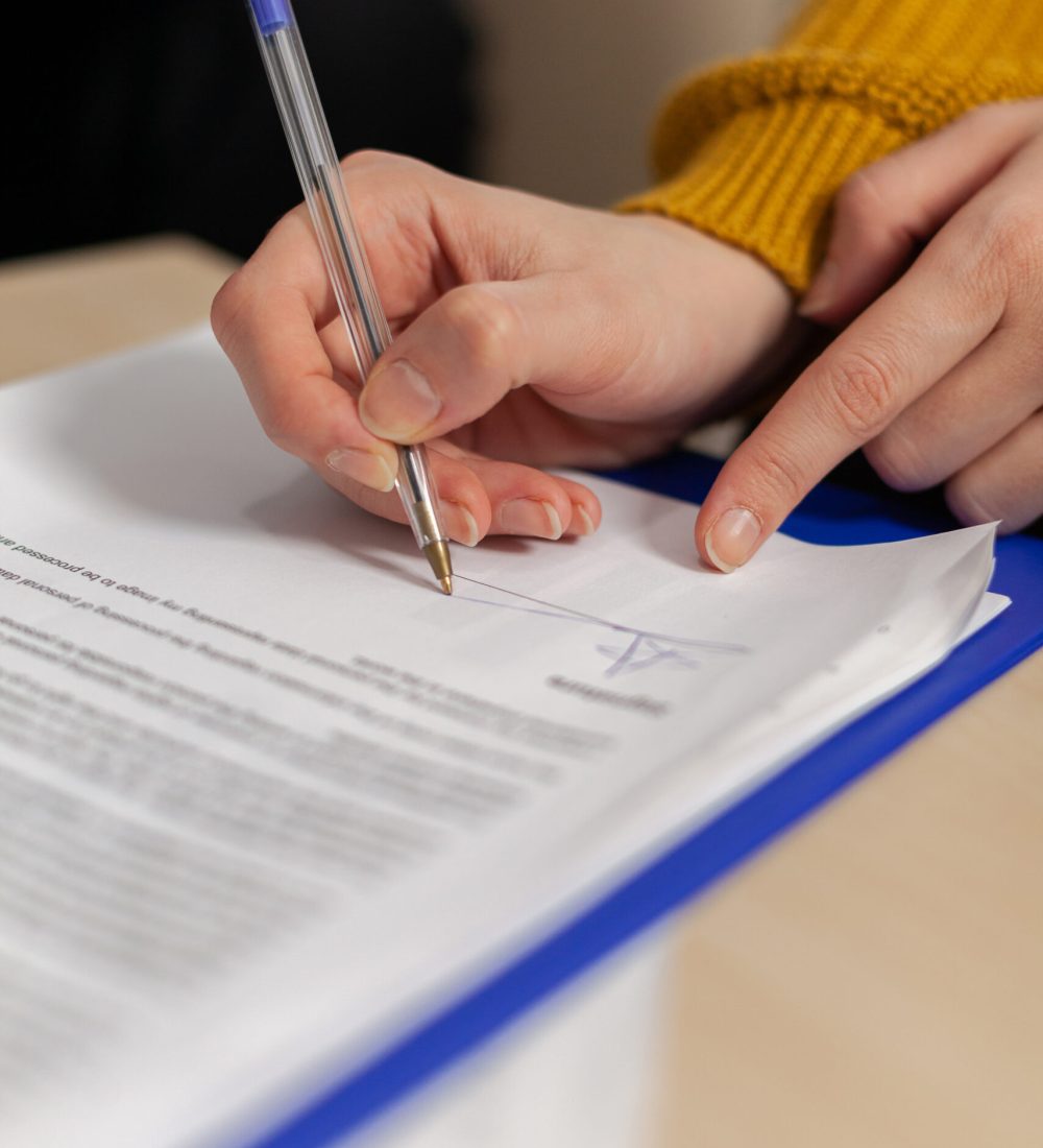 Businesswoman signing paper, partner hand puts signature on business document making employment contract agreement, taking bank loan insurance concept, patent certificate registration, close up view